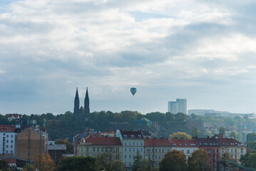 Hot air balloon flying over the city Prague at sunset background.