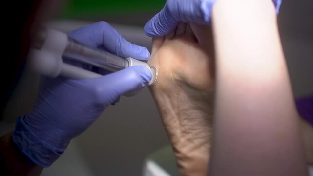 A podiatrist cleans a patient's feet in 4k