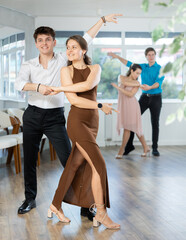 Fototapeta premium Young man and young woman dance couple latin dances in studio