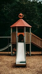 A playground with a slide and a tree in the background