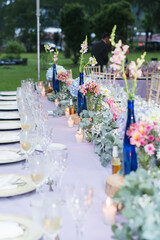 Table decorated in purple tones with glass tableware, hydrangea centerpiece. Elegant outdoor wedding. Restaurant.