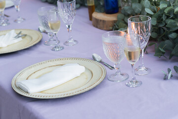 Table decorated in purple tones with glass tableware, hydrangea centerpiece. Elegant outdoor wedding. Restaurant.