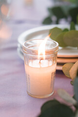 Softly Lit Candle on Elegant Table Setting with Eucalyptus