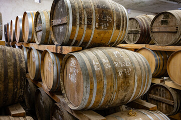 Aging process of cognac spirit in old dark French oak barrels in cellar in distillery house, Cognac...