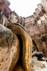 The background of one of the important tourist attractions in Sukhothai Historical Park, Wat Si Chum, has a large Buddha statue that is hundreds of years old for tourists to learn about its history.