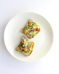 Avocado Toast with Cherry Tomatoes and Shredded Cheese on a White Plate – Minimalist Food Photography