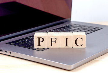 PFIC abbreviation on wooden blocks placed on a laptop keyboard