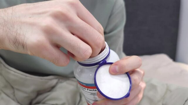 Hand taking pills, Fish oil softgel tablets omega-3 DHA EPA fatty acids nutrition dietary supplement