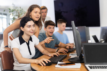 Fototapeta premium Several young people confer and work together while learning programming, participate in online games, computer courses.
