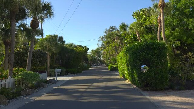 Driving on scenic road in sunny Florida. Casey Key coastal residential community picturesque streets.