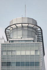 Obraz premium Close-up of a contemporary tower's rooftop with sleek steel structures and a glass facade, showcasing modern architecture with geometric patterns and minimalist design