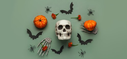 Halloween composition with skull, bats, spiders and pumpkins on green background