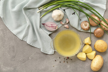 Bowl of tasty vegetable broth on grey background