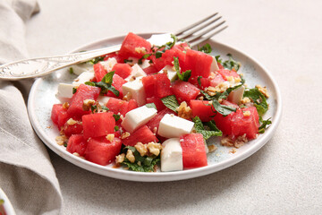 Plate of tasty watermelon salad on light background