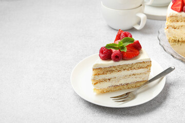 Piece of tasty sponge cake with fresh berries and mint served on light gray table, space for text