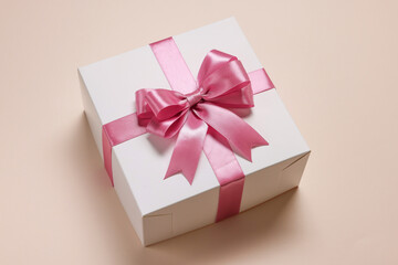 Gift box with bow on beige background