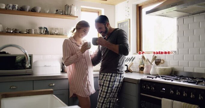 Man, woman and coffee with drinking in kitchen for morning breakfast, caffeine or talking in home with sunlight. People, espresso or pajamas on weekend for peace, relax and bonding with love or care