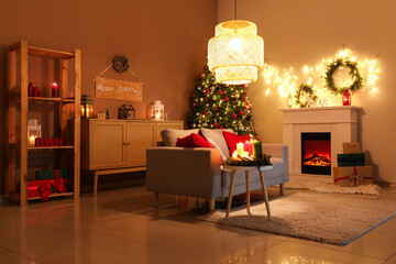 Interior of cozy living room with sofa, fireplace and Christmas tree at night