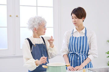 Obraz premium 嫁の料理をチェックする姑