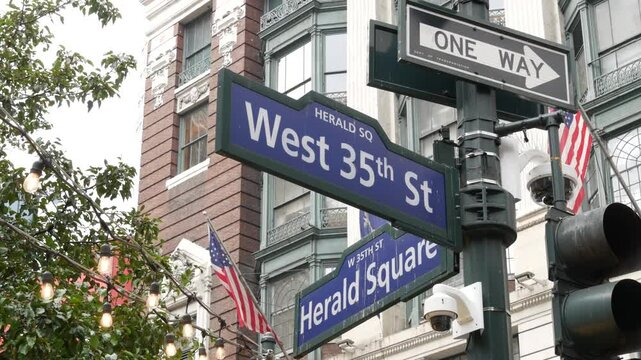 New York City crossroad, Manhattan Broadway street intersection road sign. NYC Midtown district architecture, Herald Square park, 6 Sixth avenue, United States. American flag. One way arrow road sign.