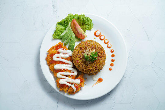 A Plate of Nasi Goreng With Chicken Katsu and Vegetables on Marble Table