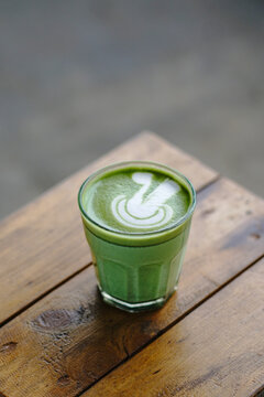 Cup of Matcha Latte With Latte Art on White Marble Table