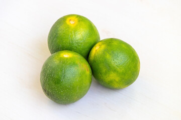 Fresh green malta fruits on a light wooden surface. It is a citrus fruit, also known as sweet orange and mosambi.
