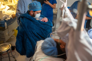 New Dad Doing Kangaroo Care with Newborn Post-Caesarean in Operating Room