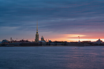 Naklejka premium View of the Peter and Paul Fortress and the Neva River against a pink dawn sky with clouds on a sunny spring morning, St. Petersburg, Russia