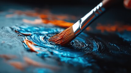 Fototapeta premium Close-Up of Paintbrush Mixing Vibrant Blue and Orange Paint on Canvas in Artistic Studio Setting