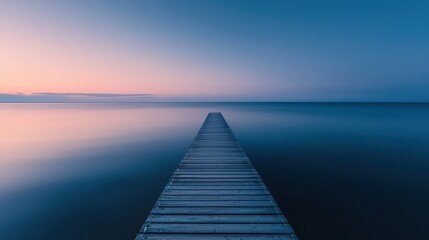 Naklejka premium Serene Wooden Pier Extending into Calm Ocean at Sunset with Clear Sky and Gentle Horizon