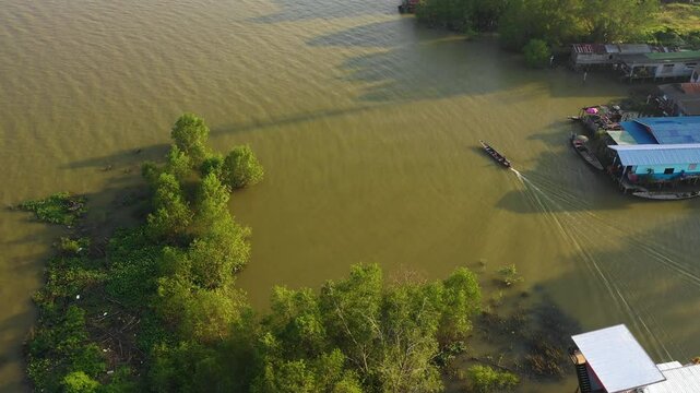 Drone shot around a fishing boat in front of the cityscape of Surat Thani, Thailand