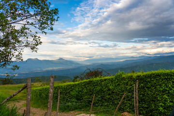 Rustic wire fence at the entrance to a dirt road in a Colombian landscape