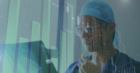 Animation of financial data processing over asian male doctor holding x-ray scan - Powered by Adobe