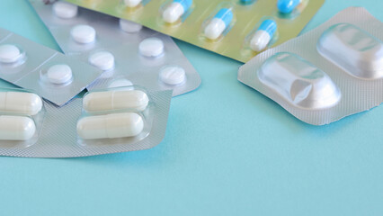 Capsules and pills blue background, image of prescription drug cost in hospital