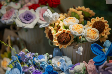 Display of knitted flowers for sale at handmade market, colorful and delicate bouquets