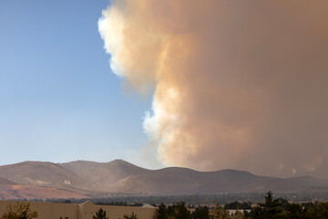 Galena G on the side of a hill in Reno with a huge orange column of smoke rising behind it