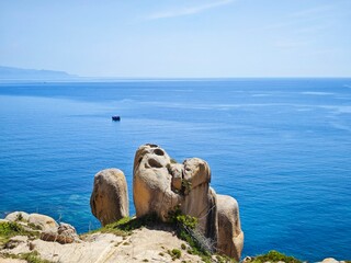 a natural rock formation overlooking a body of water, resembling a lion with distinct features like...