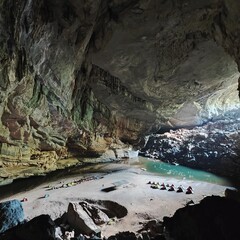 Inside En cave looking out at the cave entrance, lake and tents in the morning, the world's 3rd highest cave in Quang Binh, Vietnam