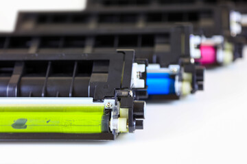 Yellow blue and magenta disposable printer cartridges on white background.
