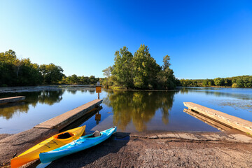 Fototapeta premium Kent lake in Kensington metro park with boat access and two kayaks at the shore.