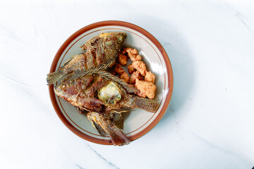 Fried fish served on a white plate. isolated on white background.
