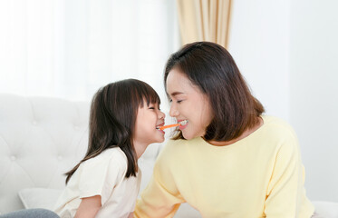 Asian mother enjoying with daughter in living room at home