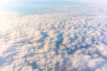 Beautiful orange and pink sunrise over the clouds, view from the plane.