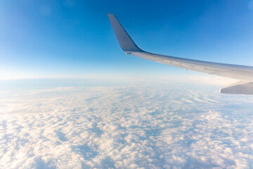 Obraz premium Beautiful salmon dawn and the wing of an airplane above the clouds.