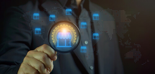 Retail concept, the sale of goods or services from a business directly to a consumer for their use. Businessman shows glowing neon line of Retail icons on magnifying glass.