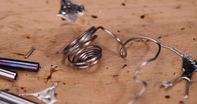 whole and molten solder and soldering iron tip on the board, solder and soldering iron tips scattered on the beech board