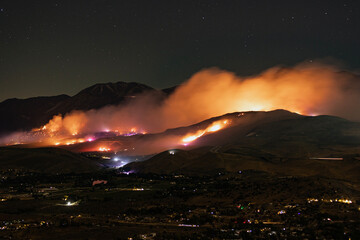 Long exposure night time, Davis fire burning in Washoe Valley on both sides of I-580 around the Galena Creek Bridge with emergency vehicles and firefighting stations lighting up the hills.