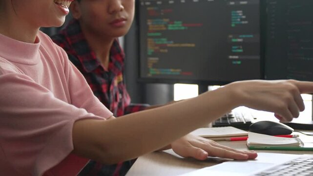 Slow motion back end software developer engineer for computer programming working together on debugging writing computing code, solving complex algorithms display on monitor in office. Burgeoning