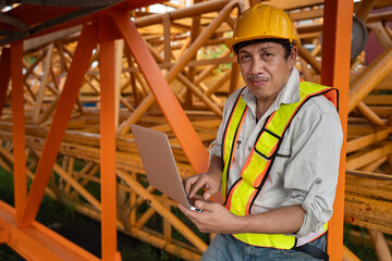 Asia engineer man worker use tablet computer checking spare crane at construction site	